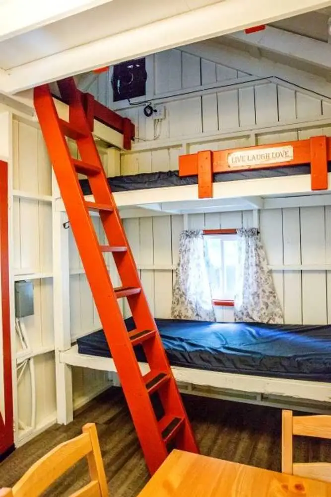 Orange ladder and bunk beds in the Family Cabin – Rustic Family Cabin at The Outpost NRG