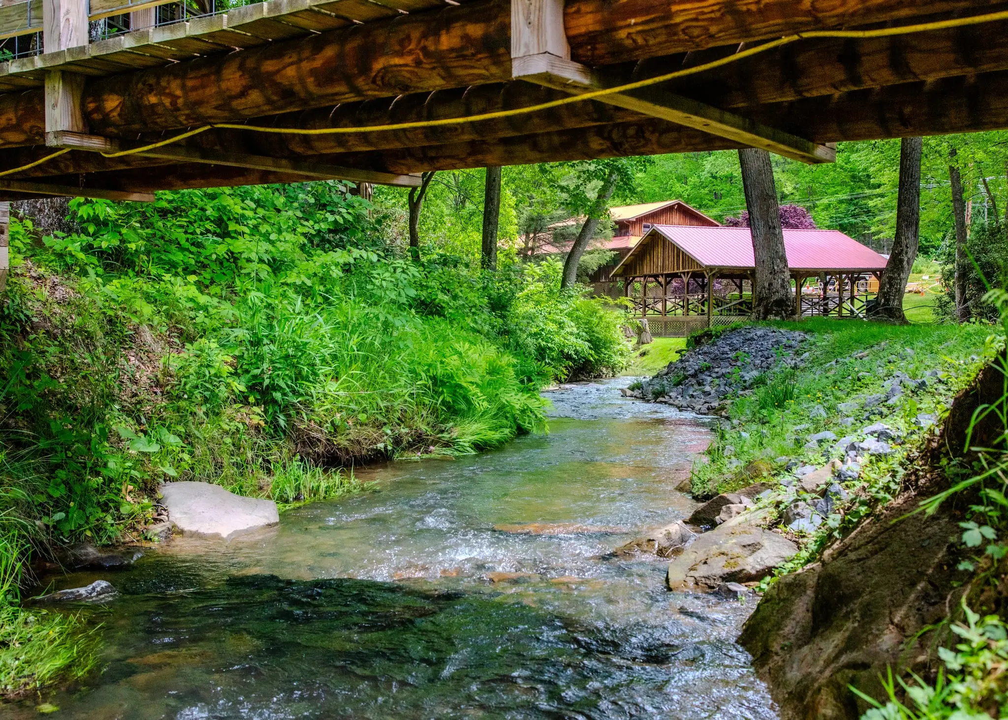 Creek-side view of the tent pavilion – Tent Pavilion at The Outpost NRG