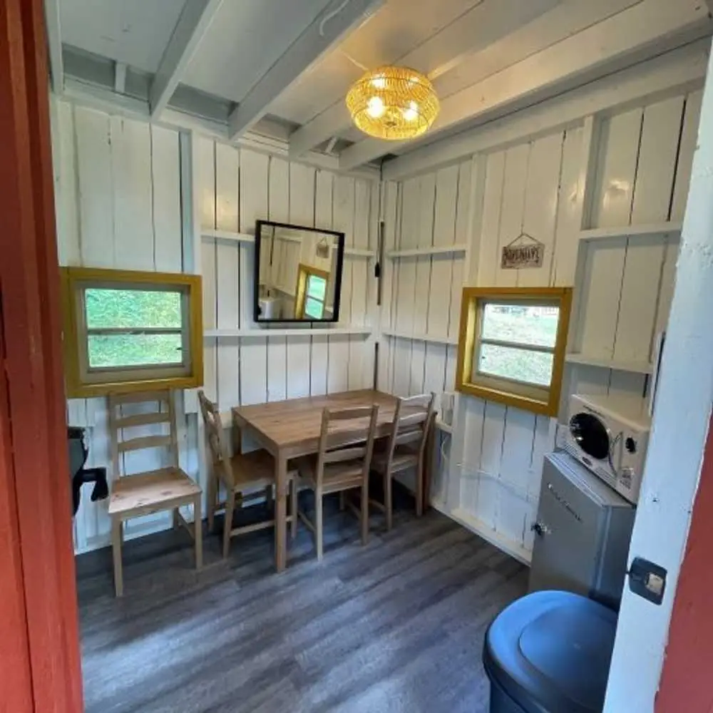 Dining table and yellow-framed windows in the Family Cabin – Rustic Family Cabin at The Outpost NRG