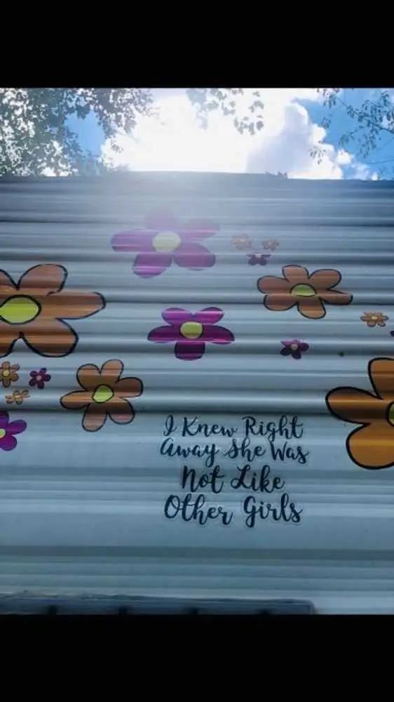 Begonia exterior with 1970s flower decals and hand-lettered quote – Begonia Vintage Camper at The Outpost NRG