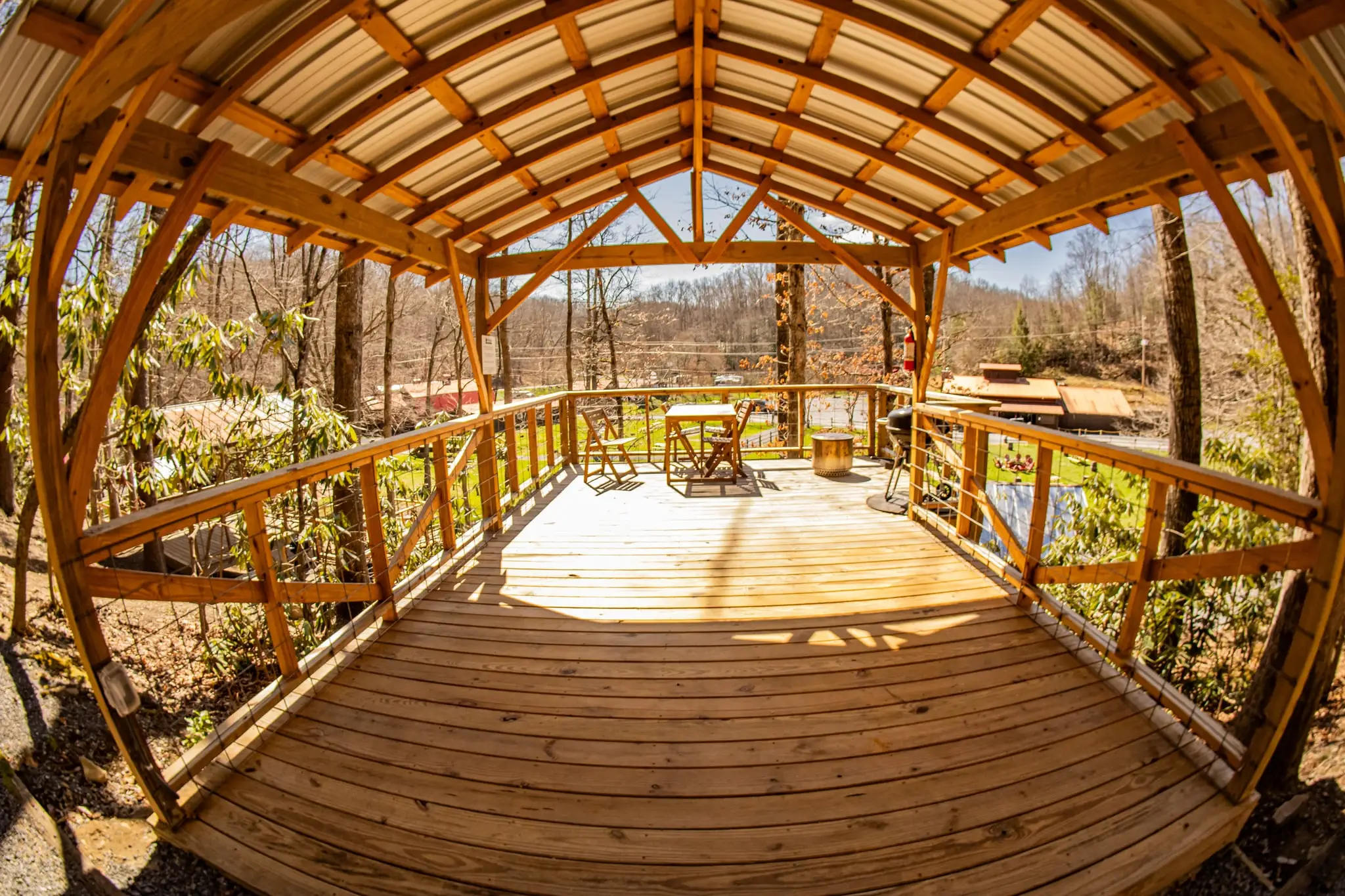 Wide view of a covered tent platform in the forest – Tent Platforms at The Outpost NRG