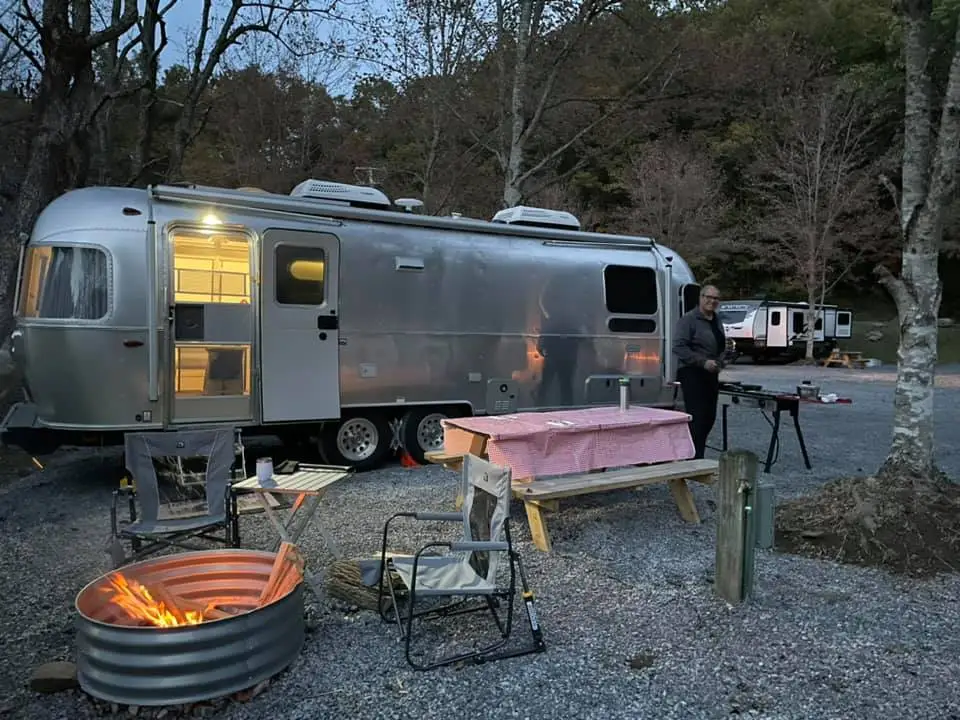 Partial hookup RV campground with gravel sites and wooded hillside – Partial Hookup RV Site at The Outpost NRG