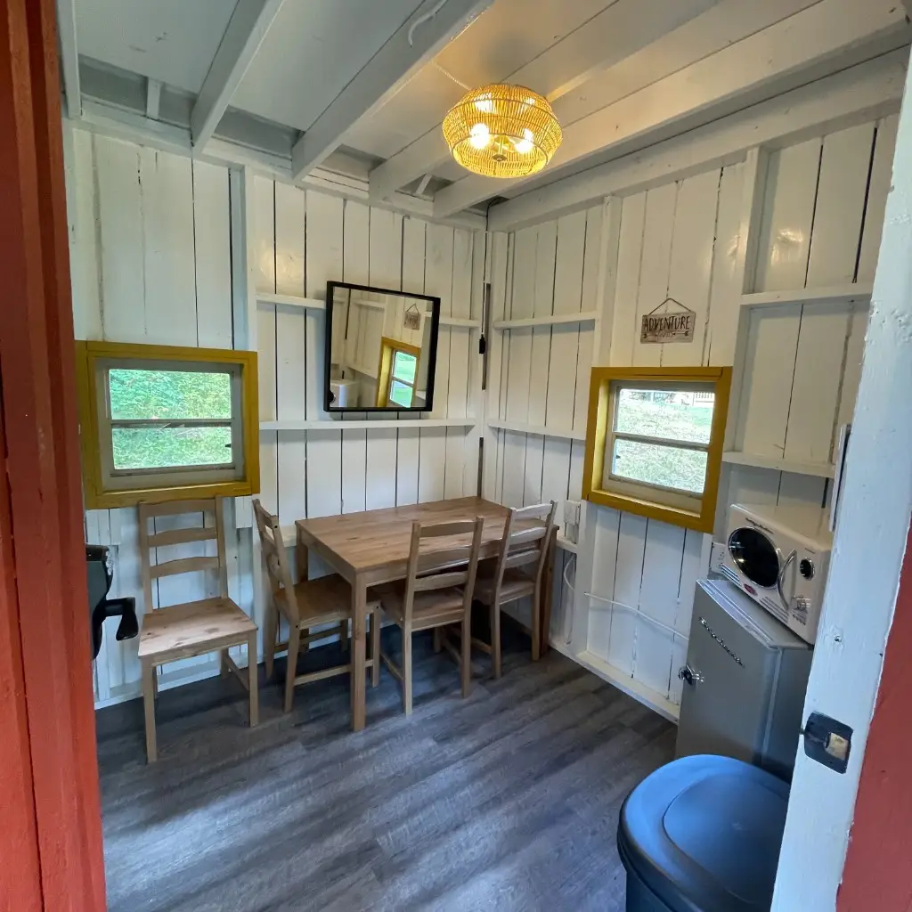 Rustic Family Cabin dining area with table, fridge, and microwave – Rustic Family Cabin at The Outpost NRG