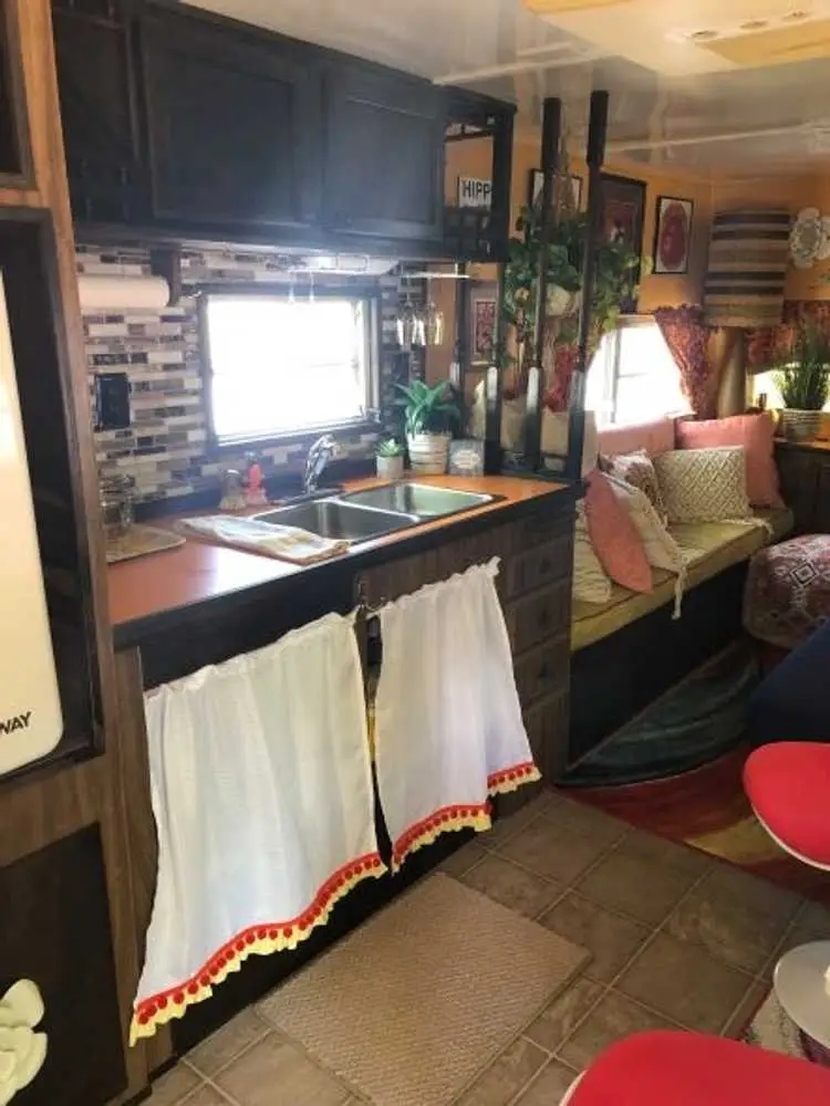 Begonia kitchen with orange countertop and sunshine yellow walls – Begonia Vintage Camper at The Outpost NRG