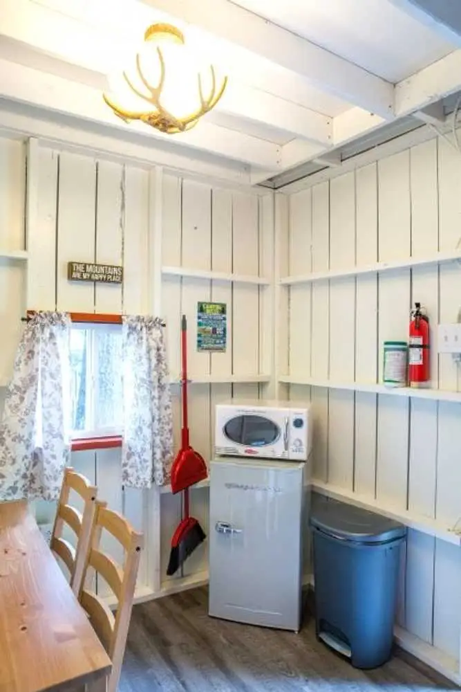 Mini fridge, microwave, and dining chairs in the Family Cabin – Rustic Family Cabin at The Outpost NRG