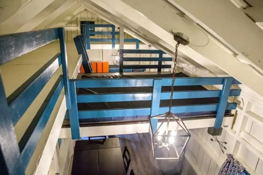 Loft sleeping area with mattresses and blue railings – Rustic Big Family Cabin at The Outpost NRG
