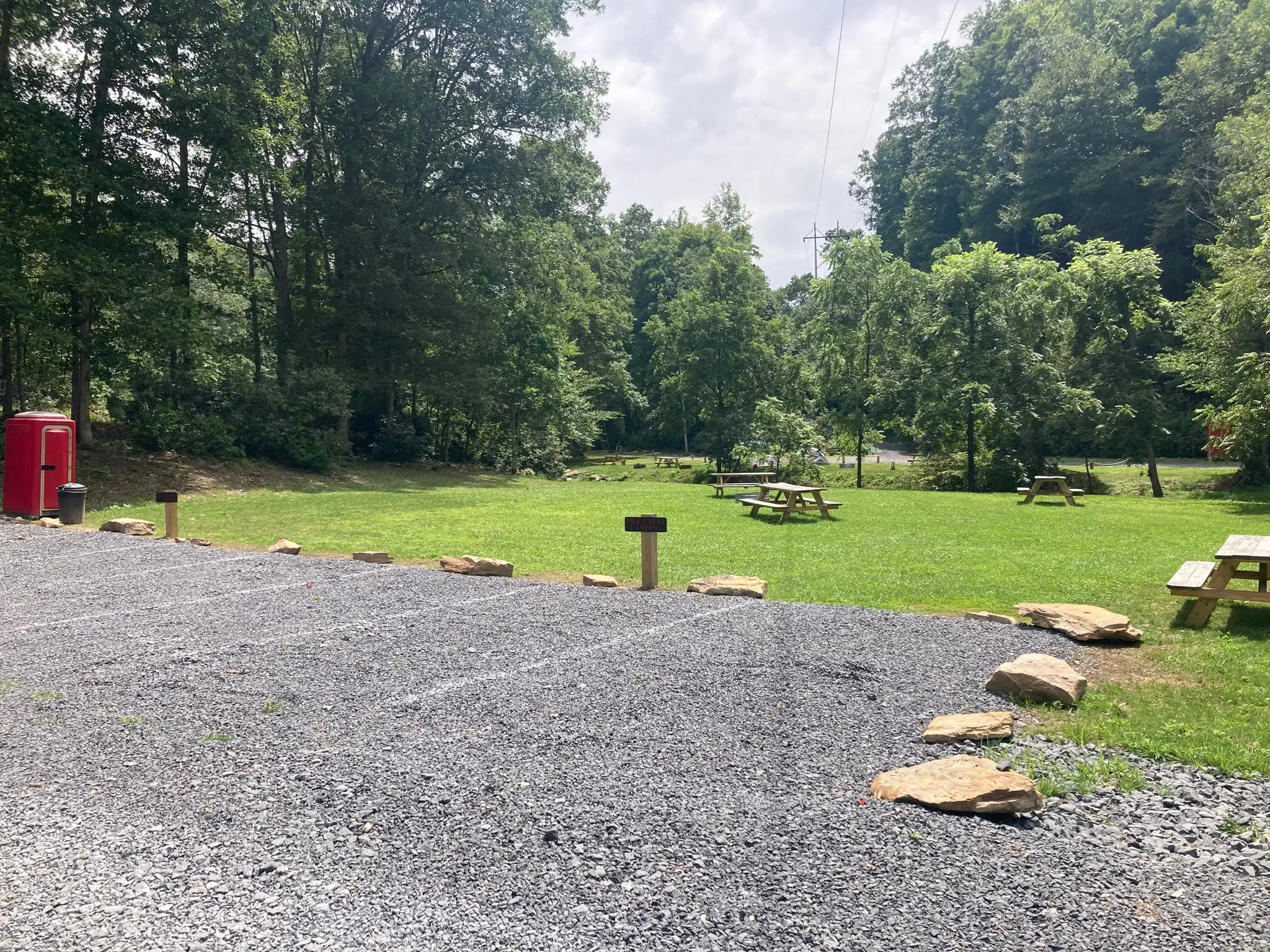 Gravel parking beside the field camping meadow – Field Tent Camping at The Outpost NRG