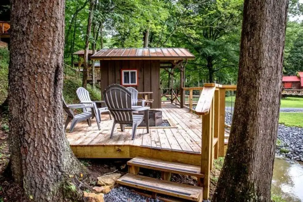Patio with fire pit beside the creek at the Bunk Cabin – Rustic Bunk Cabin at The Outpost NRG