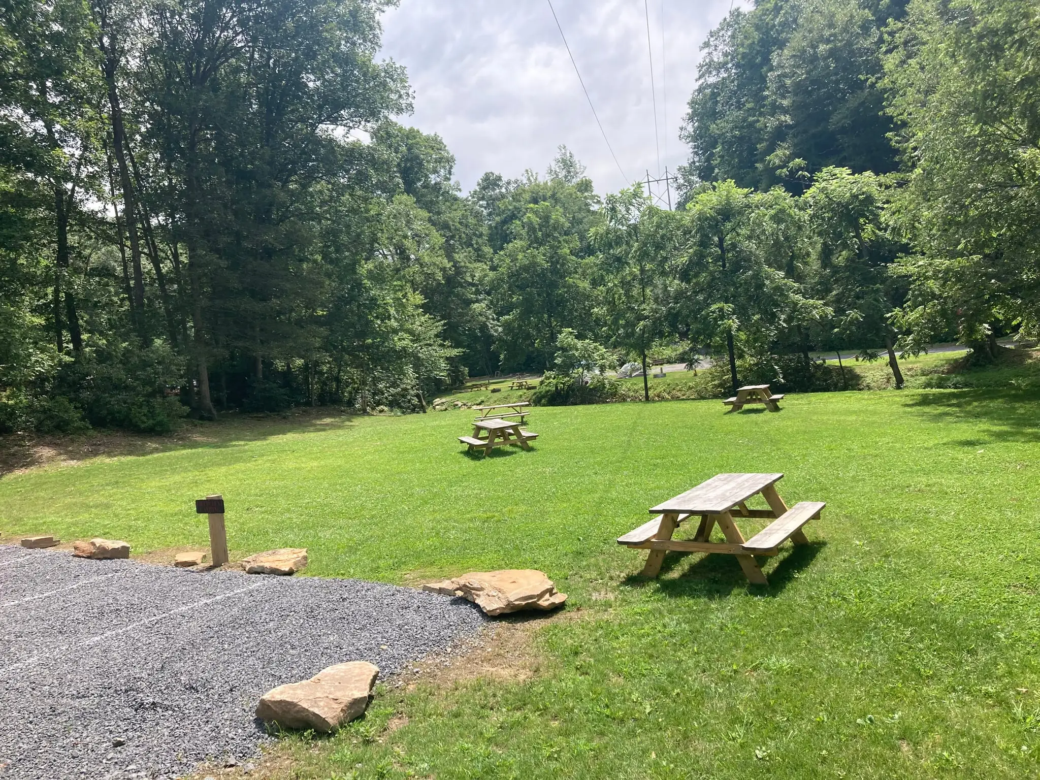 Grassy field with picnic tables – Field Tent Camping at The Outpost NRG