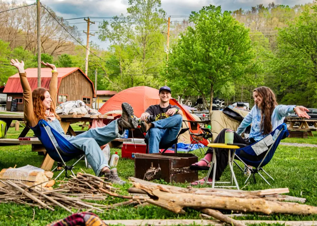 Campers relaxing in chairs beside their tents – Tent Sites at The Outpost NRG
