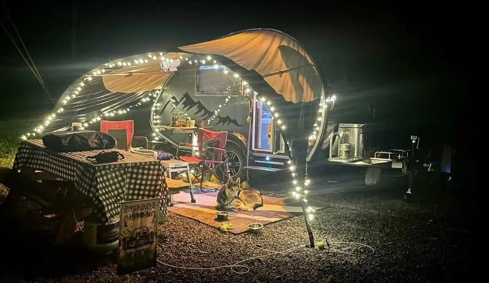 Teardrop camper with lighted awning at a partial hookup site – Partial Hookup RV Site at The Outpost NRG