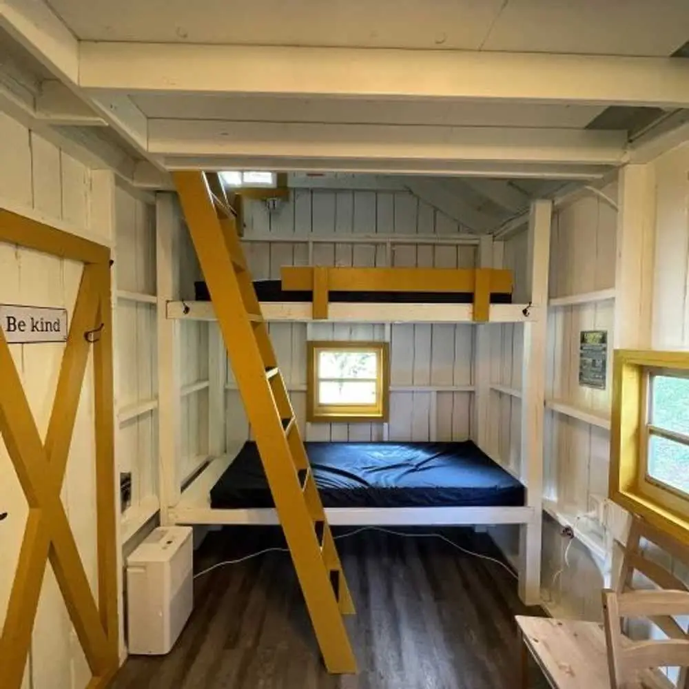 Yellow bunk beds and ladder in the Family Cabin – Rustic Family Cabin at The Outpost NRG