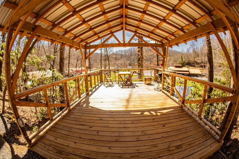 Wide view of a covered tent platform in the forest – Tent Platforms at The Outpost NRG