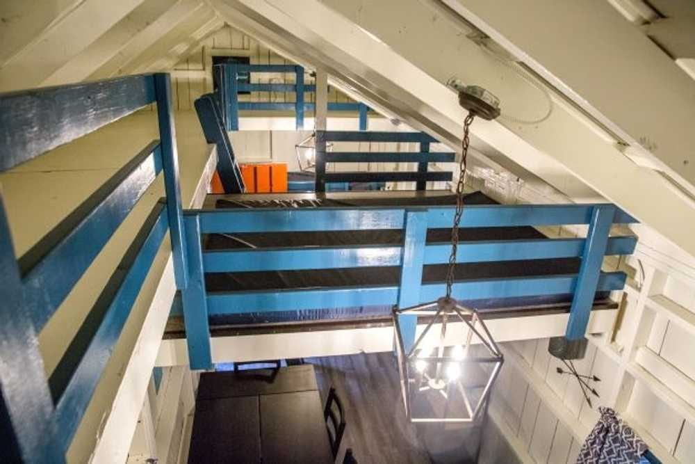 Loft sleeping area with mattresses and blue railings – Rustic Big Family Cabin at The Outpost NRG