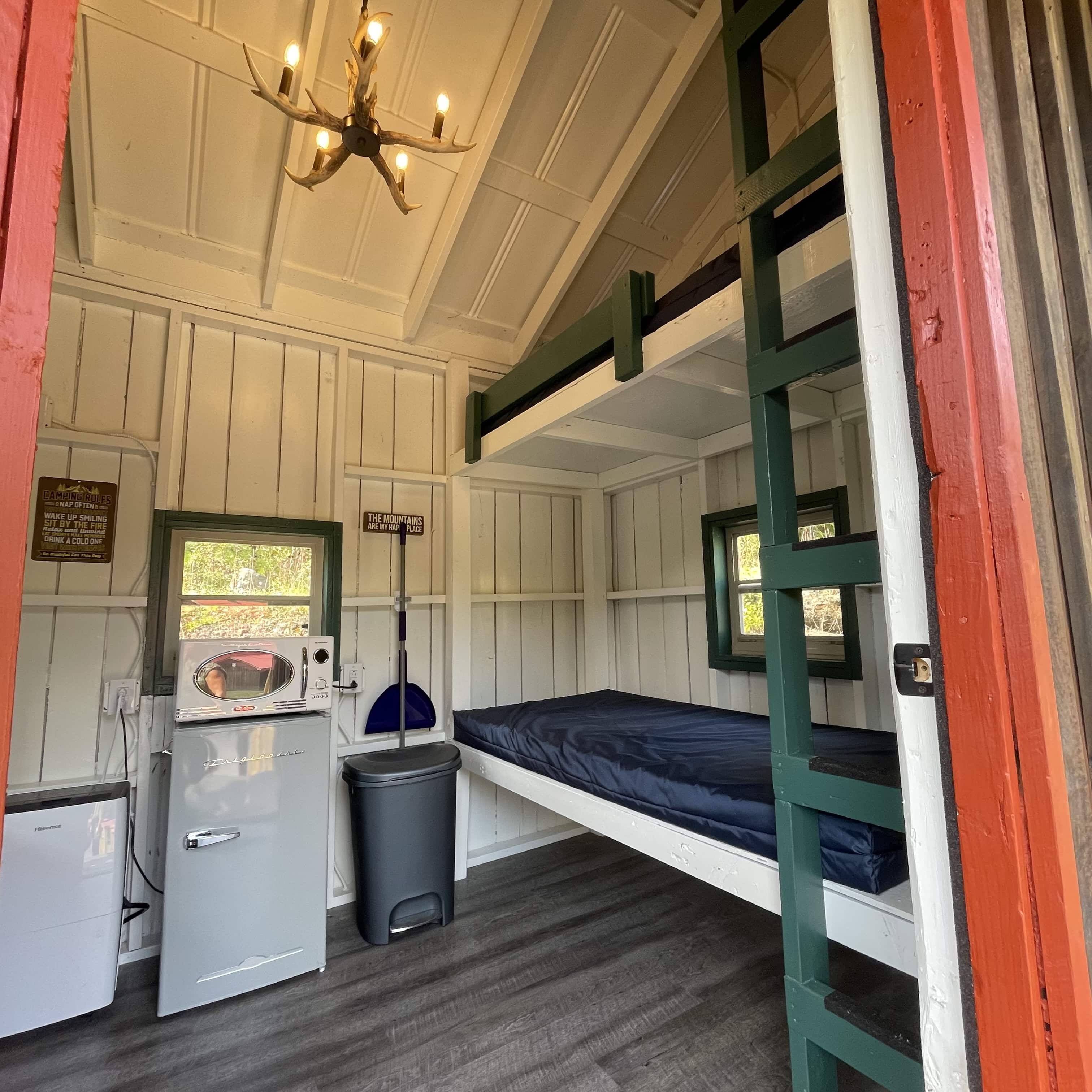 Rustic Bunk Cabin interior with bunk mattresses – Rustic Bunk Cabin at The Outpost NRG